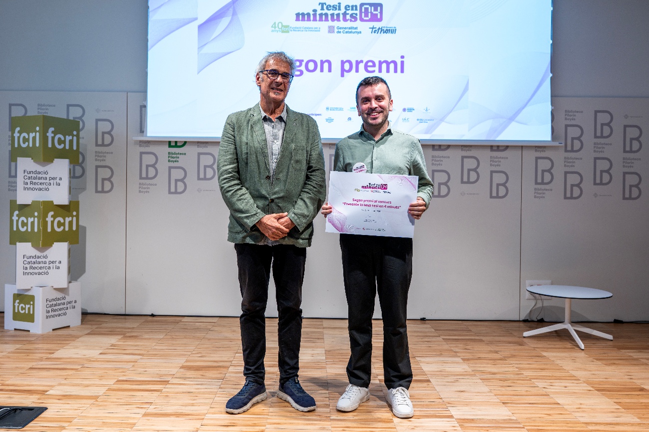 Two individuals, one in a suit and one in casual attire, stand together, presenting a certificate with a blue background and a white border, symbolizing recognition for their research work.
El contenido generado por IA puede ser incorrecto.